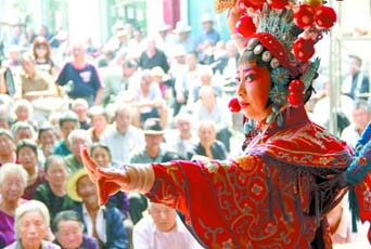 圖為8月15日戲曲演員在“流動(dòng)舞臺車”上表演傳統(tǒng)地方戲《穆桂英下山》。