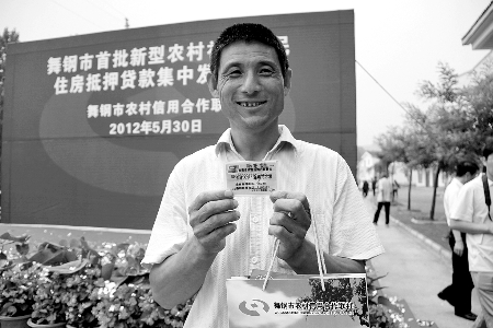 領(lǐng)到貸款，農(nóng)民開(kāi)心地笑了。