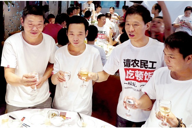 活動(dòng)發(fā)起人張楠（右二）給農(nóng)民工敬酒。