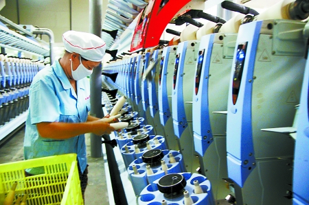 7月3日，在鄧州市永泰棉紡有限公司電腦控制全自動(dòng)紡紗車間，紡織工人正在生產(chǎn)棉紗。