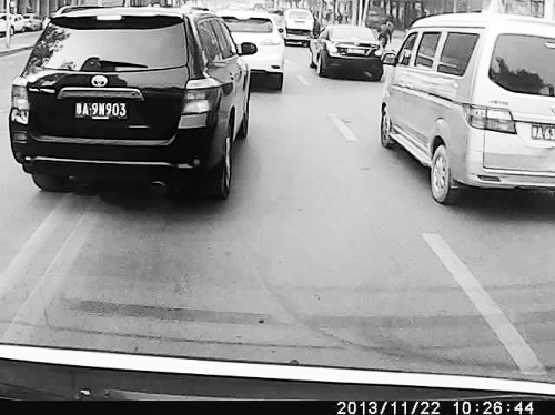 這輛黑色車輛不避讓執(zhí)行緊急任務(wù)的救護(hù)車，并壓著雙黃線變更車道。唐韜/圖