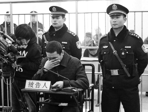 庭審中,29歲的李軍低著頭。