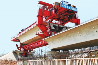 建設(shè)者們操縱巨型起重機(jī)在吊放橋墩。記者鄧放攝