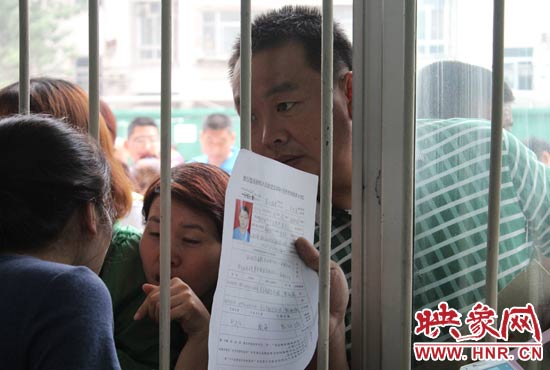 不少家長擠在報名窗口前咨詢報名事宜。