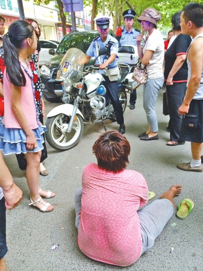 在鄭州優(yōu)勝南路東三街交叉口向東100米處，一名短發(fā)中年女子平躺在路南快車道上，身旁還有一只掉落的拖鞋