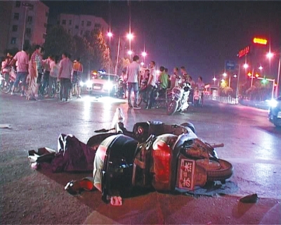 一輛白色無牌奧迪轎車在通過路口時，將一名騎電動車的女子撞飛十多米