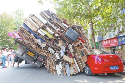 紅色小轎車(chē)被砸，卡在路邊動(dòng)彈不得。