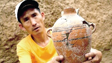 　　考古工作人員展示出土的仰韶文化時(shí)期代表性彩陶。