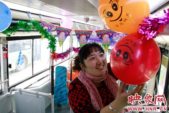 鄭州快速公交B3區(qū)間線車長李鵬云在車廂里懸掛氣球，布置圣誕車廂，營造歡樂圣誕氛圍