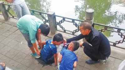 男孩被救出后，圍觀群眾幫他控水換衣服。