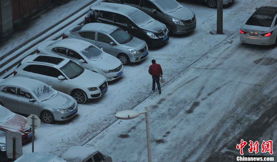 11月18日，行人在沈陽街頭的積雪中穿行。