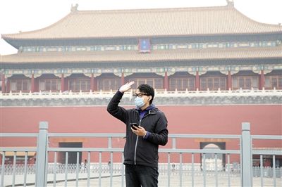 11月1日，北京大部分地區(qū)重度污染，一名游客戴著口罩在午門前揮手跟朋友打招呼。 實習(xí)生 王飛 攝