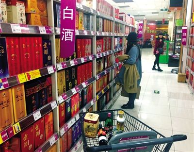 顧客在商場的高檔白酒貨架前駐足挑選。春節(jié)臨近，受“禁令”影響，以高檔白酒為代表的節(jié)日禮品市場面臨考驗。記者 王遠征 攝