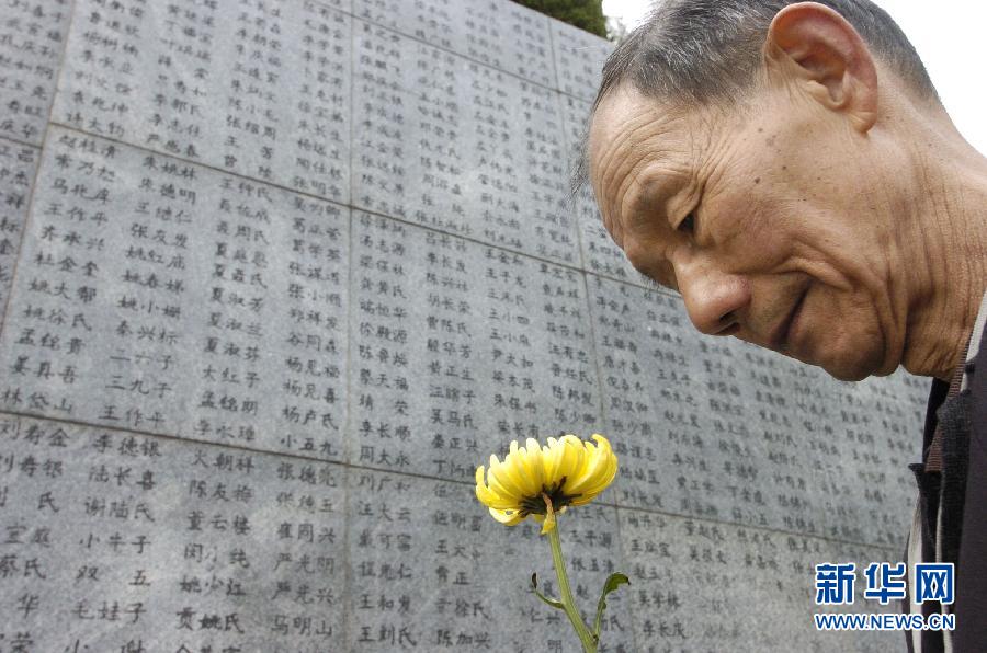 2006年4月5日，74歲的南京大屠殺幸存者佘子清手捧鮮花，祭奠被日軍殺害的母親。