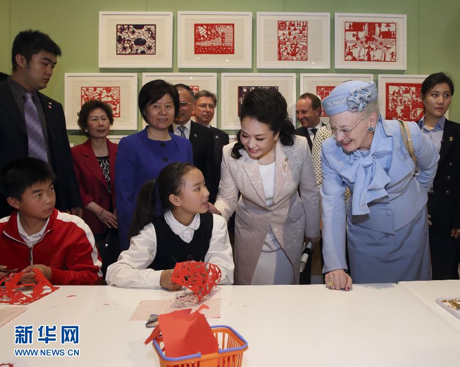 這是彭麗媛和瑪格麗特二世與根據(jù)安徒生童話中人物和情節(jié)制作剪紙的孩子交談。