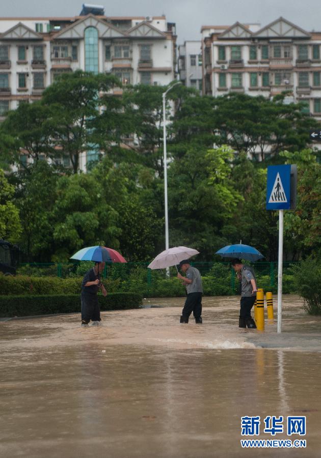 5月11日，人們在深圳西麗涉水行走。