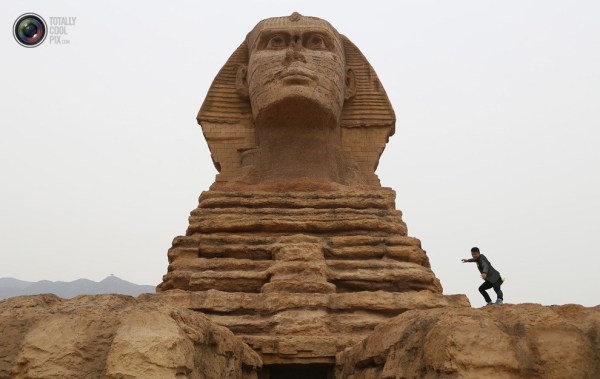 石家莊郊外，一名男子與山寨版獅身人面像合影留念。