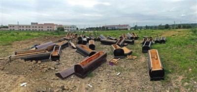40多副棺木被砸壞后，扔在荒地上。
