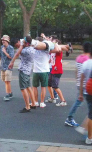 　四名外籍男子一同扛起醉漢拍照。