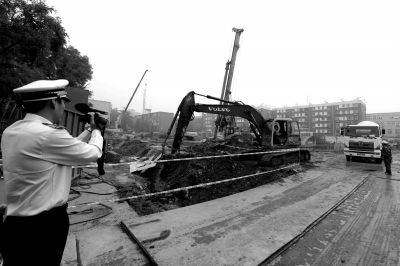 學(xué)院南路一科研樓項目有3臺挖掘機(jī)違規(guī)進(jìn)行土方作業(yè)，被城管隊員當(dāng)場責(zé)令停工。京華時報記者歐陽曉菲攝