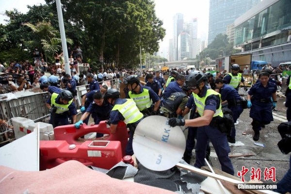 10月14日，警方清除金鐘道障礙物。大批警員在金鐘道現(xiàn)場(chǎng)清拆障礙物。部分警員戴上頭盔將障礙物移走。