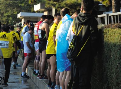 2013年10月20日，北京馬拉松比賽，由于廁位有限，一些選手在綠化帶“就地解決”。圖/IC