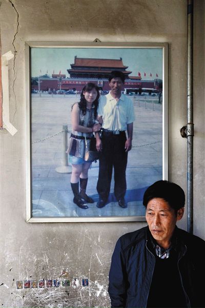 11月14日，承德市平泉縣，潘小梅父母的家，潘小梅父親靠在墻上，身后掛著數(shù)年前他和潘小梅在北京的合影照片。新京報記者