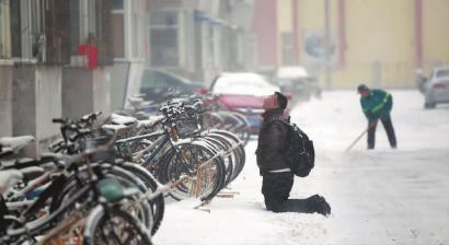 小伙子跪在樓前，一直抬頭看著樓上。 孫立國(guó)/攝