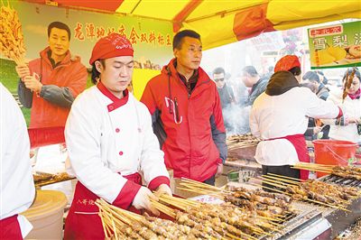 賣羊肉串?dāng)偽焕习遐w山（穿紅衣者）。新京報(bào)記者