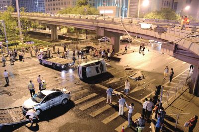 路虎沖下國貿(mào)橋砸中一輛起亞轎車，橋上厚達幾十厘米的水泥護欄被撞斷，碎石四處散落，數(shù)十群眾在現(xiàn)場圍觀。