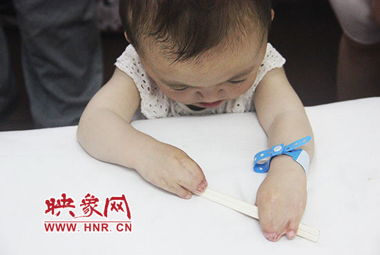 孩子握著筷子發(fā)呆。