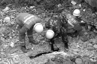 搜救人員正在用探視儀器觀看被掩埋層的情況。