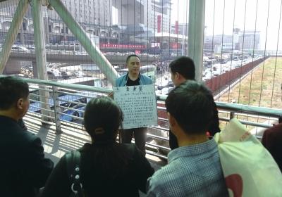 韓先生在北京西站天橋上籌錢(qián)。京華時(shí)報(bào)記者陶冉攝
