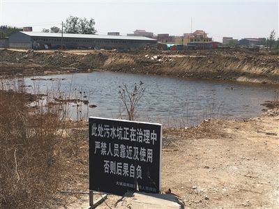 化肥廠滲坑的三分之一經(jīng)過(guò)治理，但水質(zhì)仍然呈黃褐色。