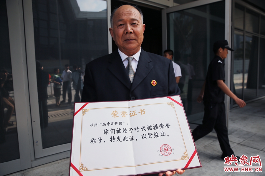 河南鄧州“編外雷鋒團(tuán)”團(tuán)長(zhǎng)宋清梅向眾多記者展示中宣部授予的“時(shí)代楷?！睒s譽(yù)證書(shū)。