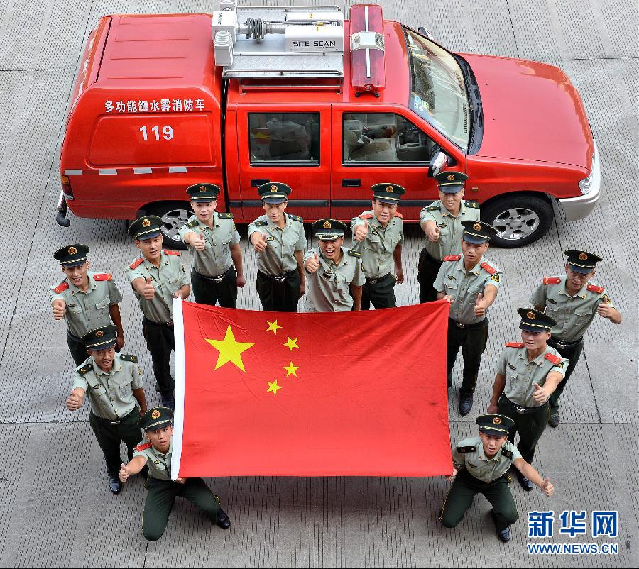  9月25日，武警浙江嘉興消防官兵與國(guó)旗合影。