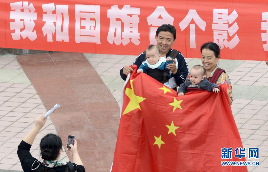 9月27日，在山東德州市中心廣場(chǎng)，市民與國(guó)旗合影。