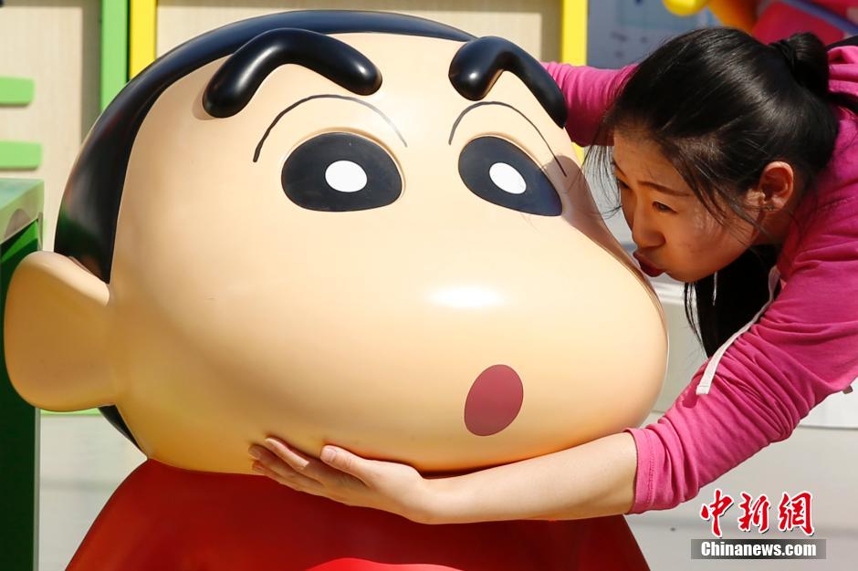 4月22日，游客與蠟筆小新合影?！跋灩P小新25周年紀(jì)念特展”日前在北京開展，吸引了不少市民游客。