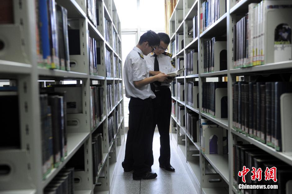 5月8日，武漢輕工大學(xué)保安吳濤與江力在圖書館交流學(xué)習(xí)。中新社發(fā) 張暢 攝