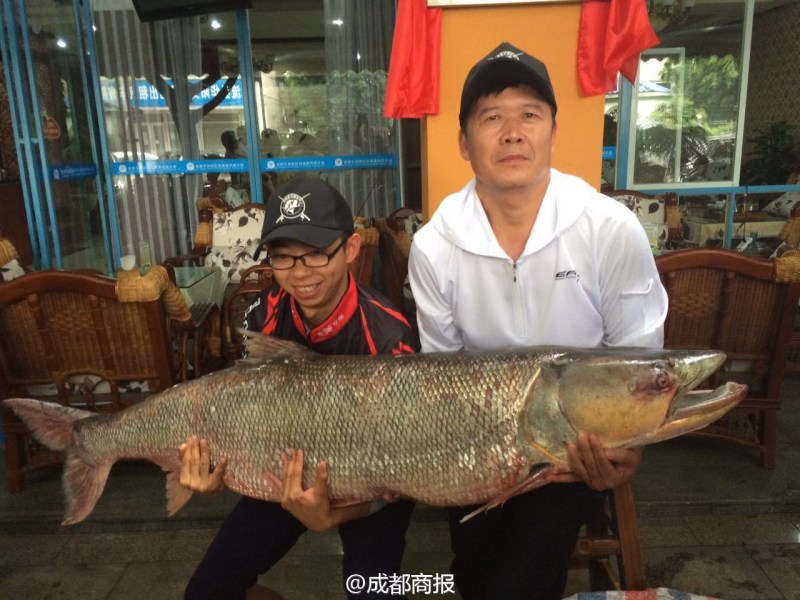 這對(duì)父子抱著他們釣起的大魚