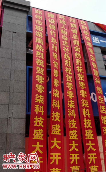 路邊一棟樓上懸掛著二三十條紅色條幅，全部是祝賀一家公司開業(yè)的。