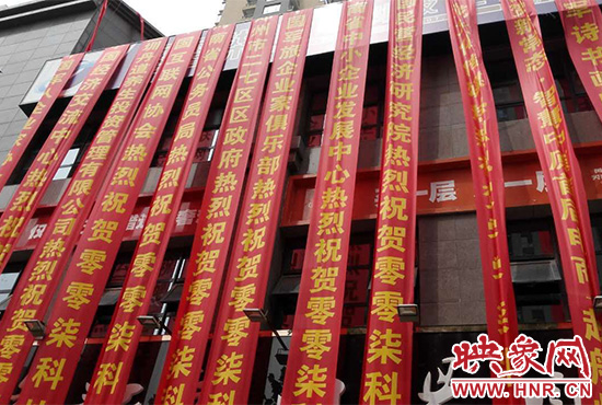 路邊一棟樓上懸掛著二三十條紅色條幅，全部是祝賀一家公司開業(yè)的。