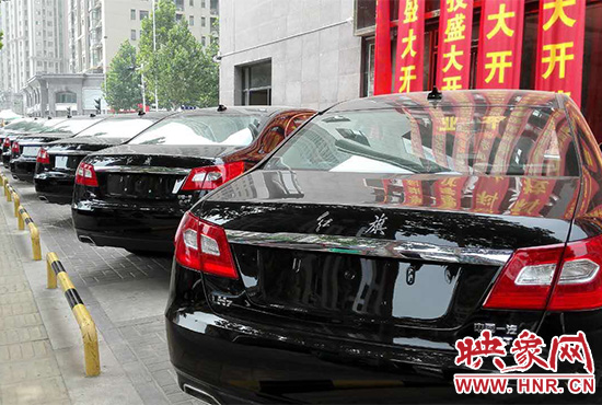 路邊一棟樓上懸掛著二三十條紅色條幅，全部是祝賀一家公司開業(yè)的。