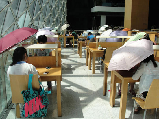 2015年8月2日，深圳圖書館，“太陽曬進(jìn)來很熱的，我們都要撐著傘讀書?！? complete=