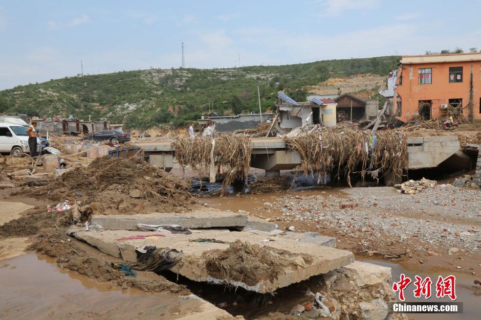 圖為洪水過后，坍塌的橋梁上遺落大量雜草。