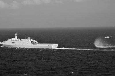 11日，抵達馬航飛機失聯(lián)海區(qū)的海軍井岡山艦與艦載直升機協(xié)同展開立體搜救行動。新華社發(fā)