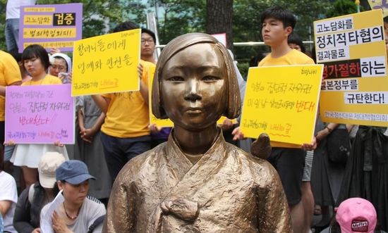 7月2日，在韓國首爾的日本駐韓國大使館前，民眾在慰安婦少女像旁手持標(biāo)語參加抗議活動(dòng)。
