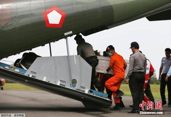資料圖：當?shù)貢r間2015年1月19日，印尼龐卡蘭布翁，依斯干達空軍基地，救援隊成員正將裝有亞航失事飛機遇難者尸體的棺材抬上一架CN2950運輸機。