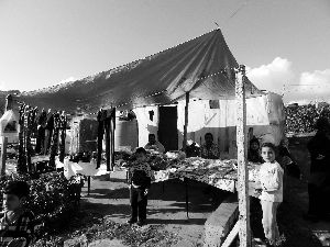 黎巴嫩一敘利亞難民營(yíng)，難民支起攤鋪賣衣服掙錢。