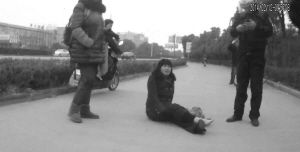 鄭大姐坐在地上，警方趕到進(jìn)行施救。（視頻截圖由警方提供）